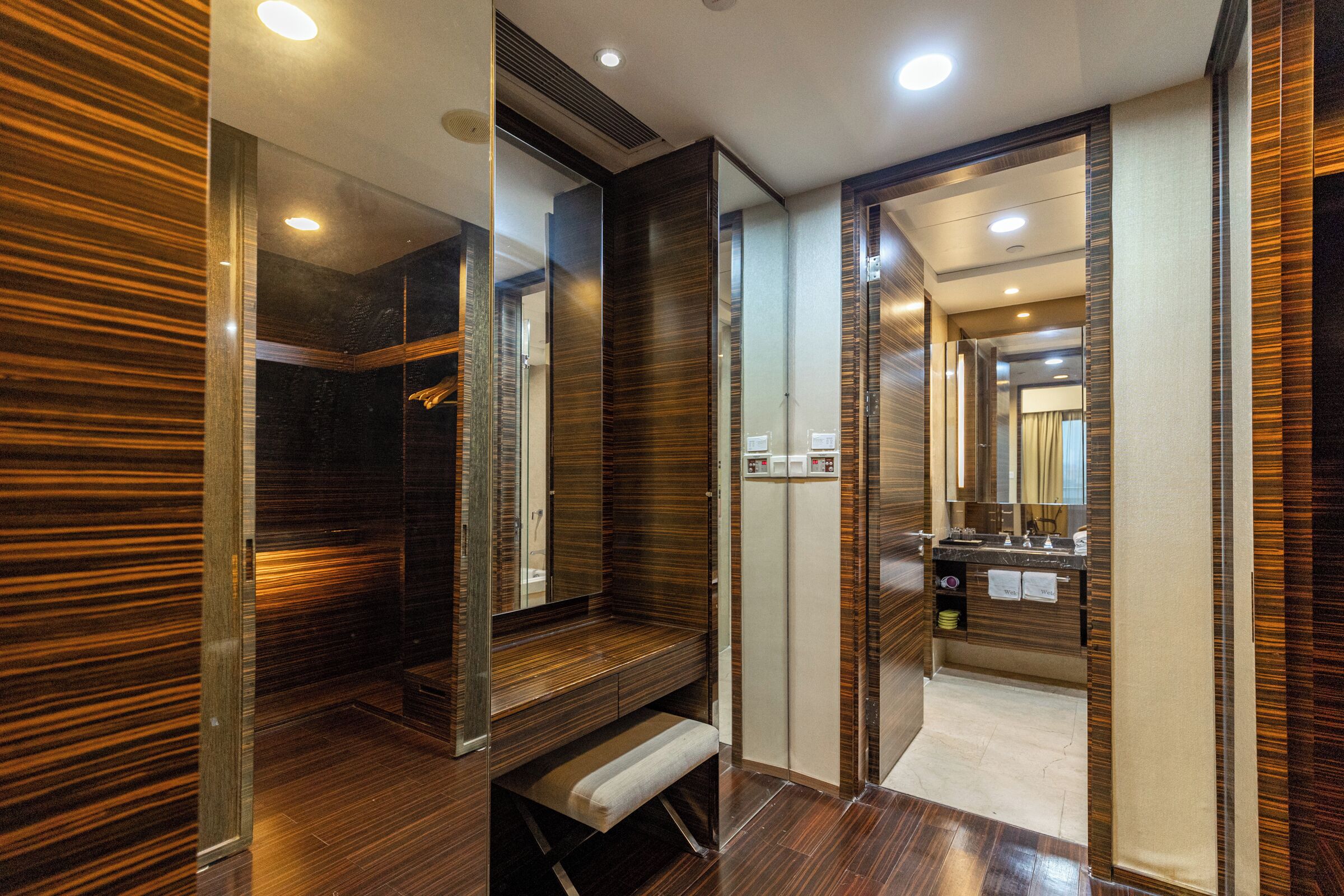 Une salle de bain moderne avec un meuble-lavabo en bois, un banc et un miroir.