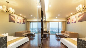 A hotel room with two beds, a sofa, a coffee table, and a view of the city. - Xingyi International Hotel Poly Store (Guangzhou)