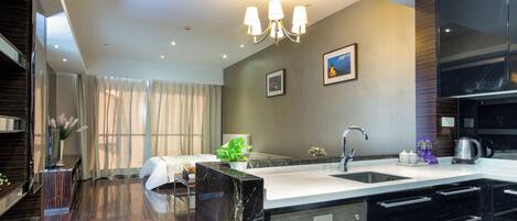 A modern kitchen with a large island, built-in appliances, and a dining area with a view of the city.