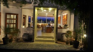 A hotel entrance with a reception desk, seating area, and potted plants. - Amaara Sky Hotel (Kandy)