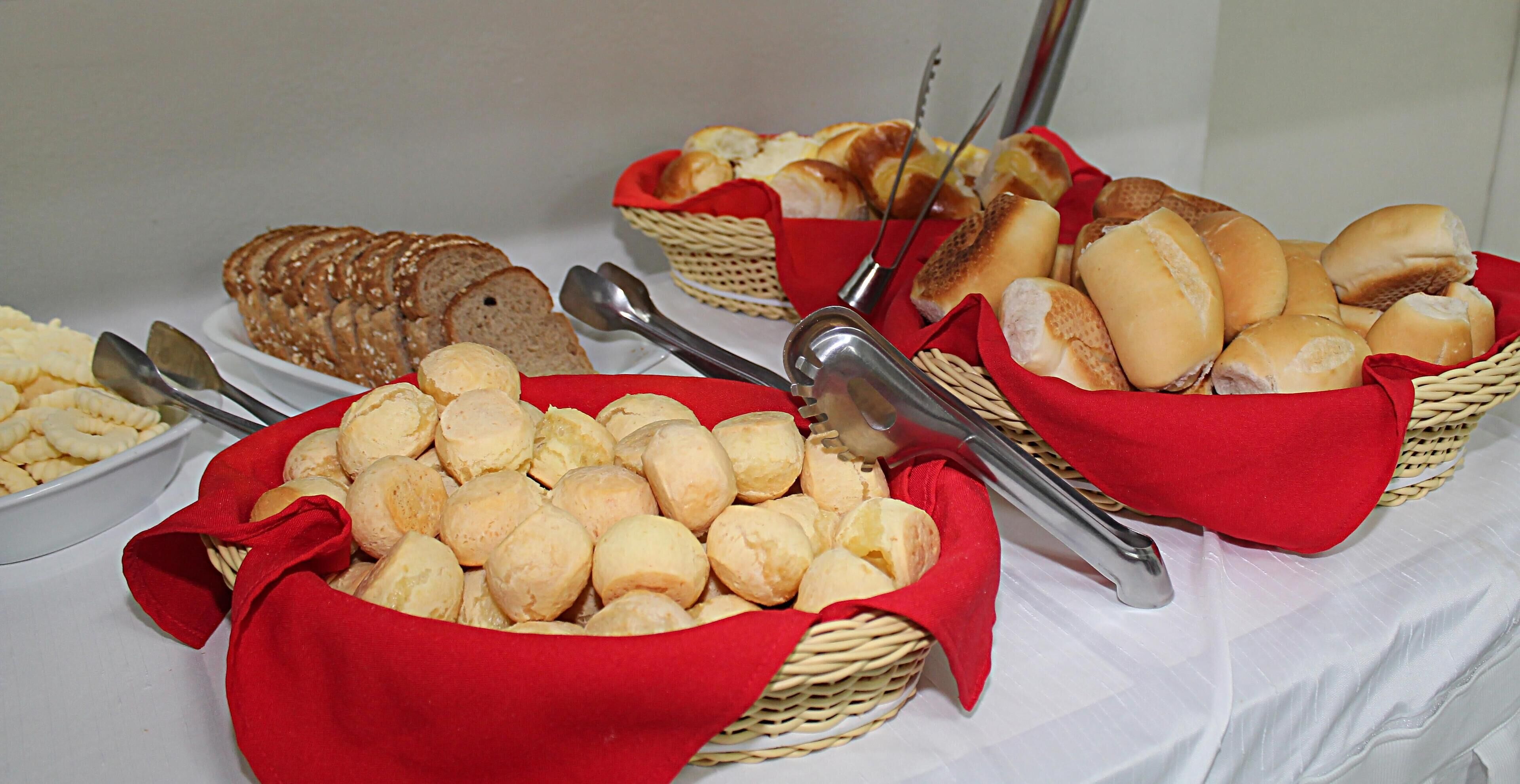 A buffet table with various bread and pastries.