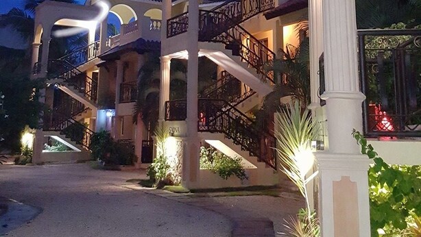 A multi-story building with a grand entrance, multiple balconies, and a well-lit facade. - Aparta-Hotel Villa Baya (San Rafael del Yuma)