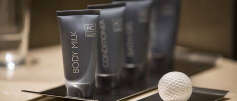 A row of AC Hotels body care products on a countertop.