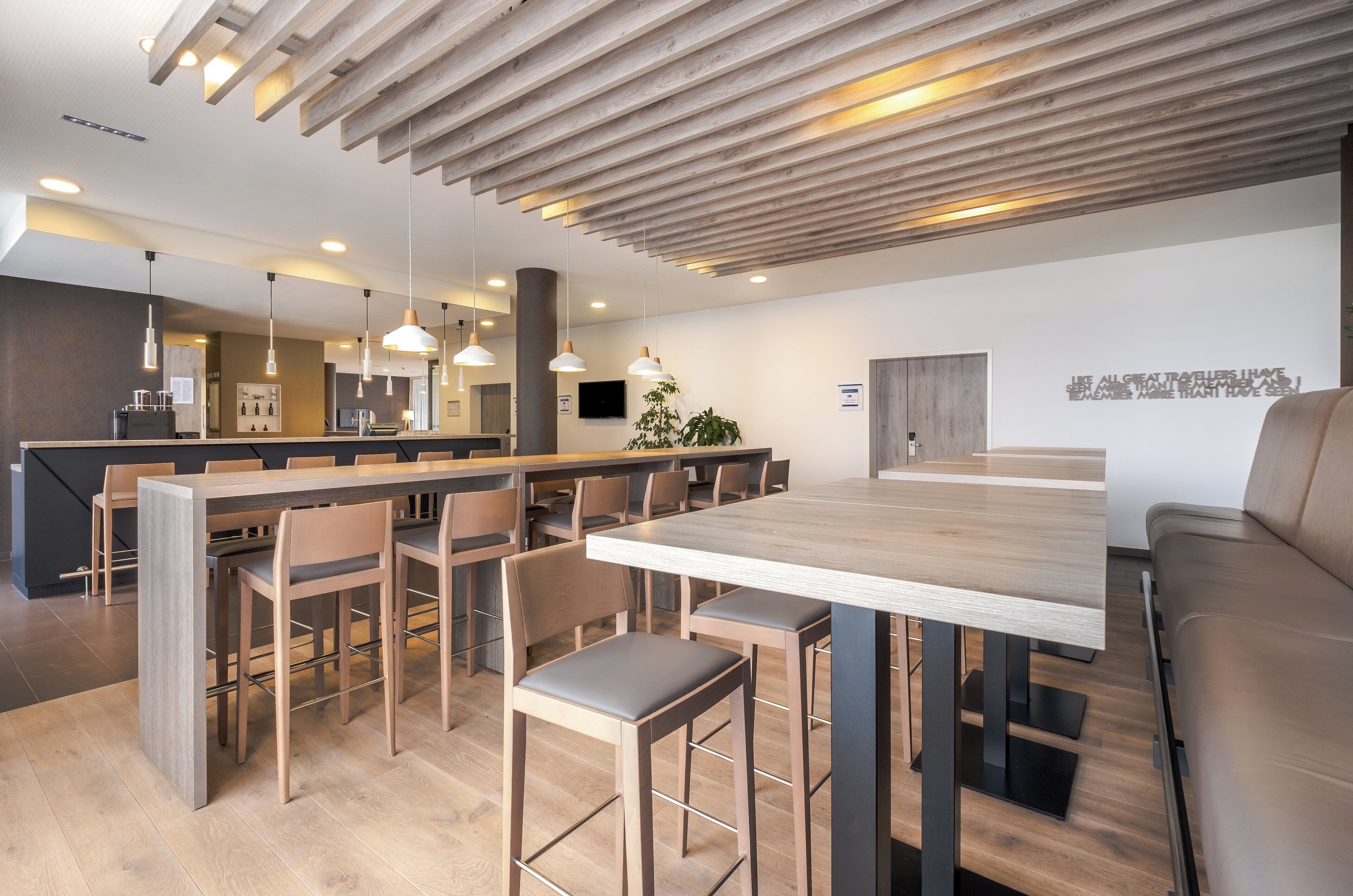 Cocina moderna con isla central, asientos tipo bar y zona de comedor con una mesa grande y sillas.