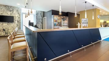 Eine moderne Bar mit Theke, Sitzgelegenheiten und einer mit Flaschen bestückten Bar.