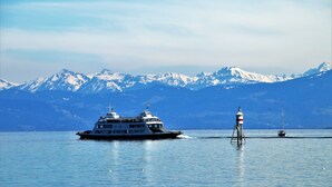 A large cruise ship with multiple decks and a lighthouse in the background. - Holiday Inn Express Friedrichshafen by IHG (Friedrichshafen)