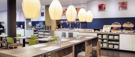 A modern cafe with wooden tables, chairs, and hanging pendant lights.