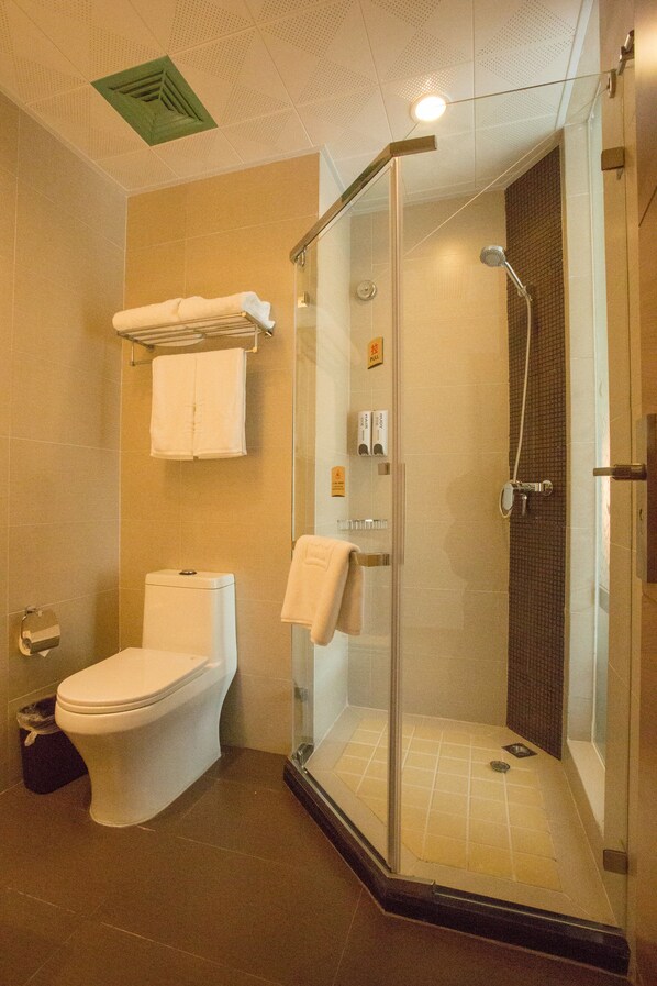 A bathroom with a toilet, a glass-enclosed shower, and a towel rack.