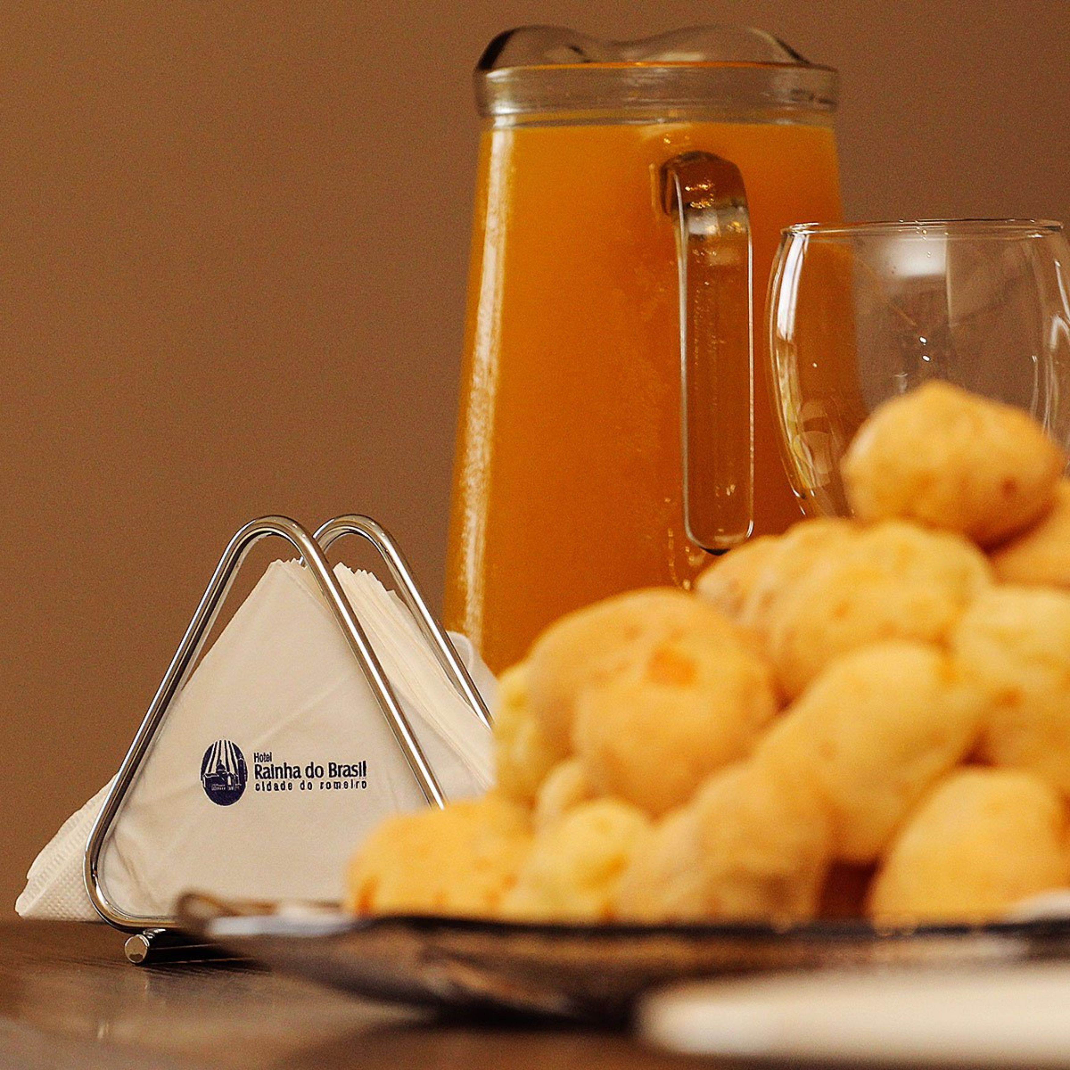 A glass mug, a pitcher, and a plate of cheese puffs.