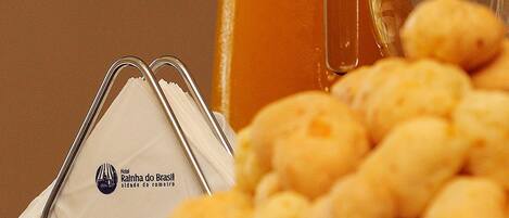 A glass mug, a pitcher, and a plate of cheese puffs.
