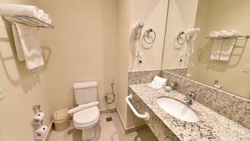A bathroom with a toilet, sink, and towel rack.