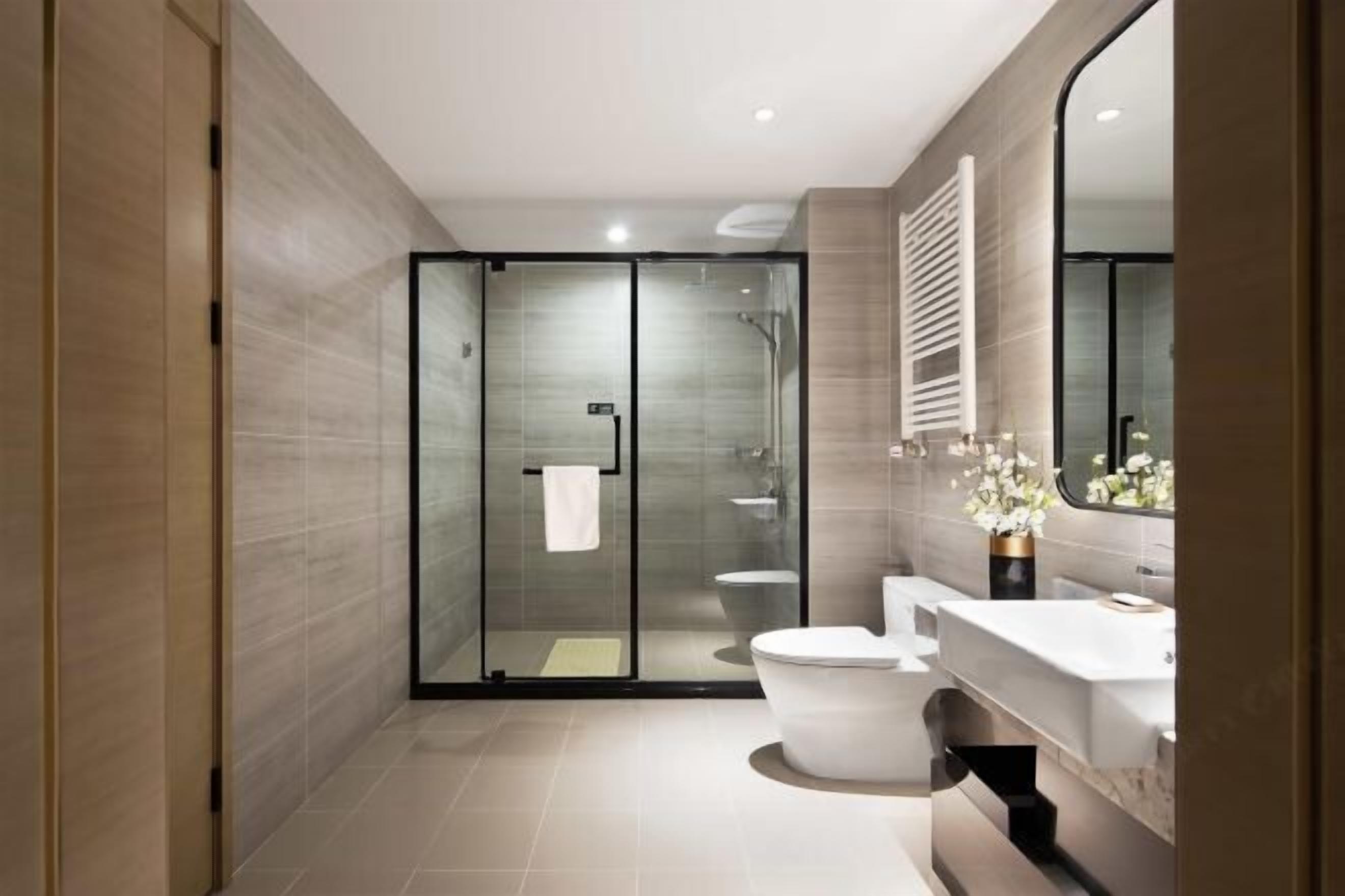 Une salle de bain moderne avec une douche à parois de verre, des toilettes et un lavabo avec un miroir.