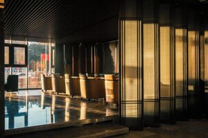 A modern interior with a pool, seating area, and large windows.