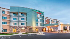 Een Courtyard Marriott hotel met een modern design, meerdere verdiepingen en een overdekt entreegebied.