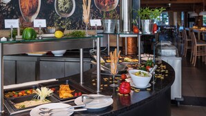 A buffet setup with various food items and utensils. - alpenhotel Kaiserfels (Sankt Johann in Tirol)