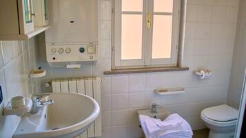 Ein Badezimmer mit Waschbecken, Toilette und Fenster.