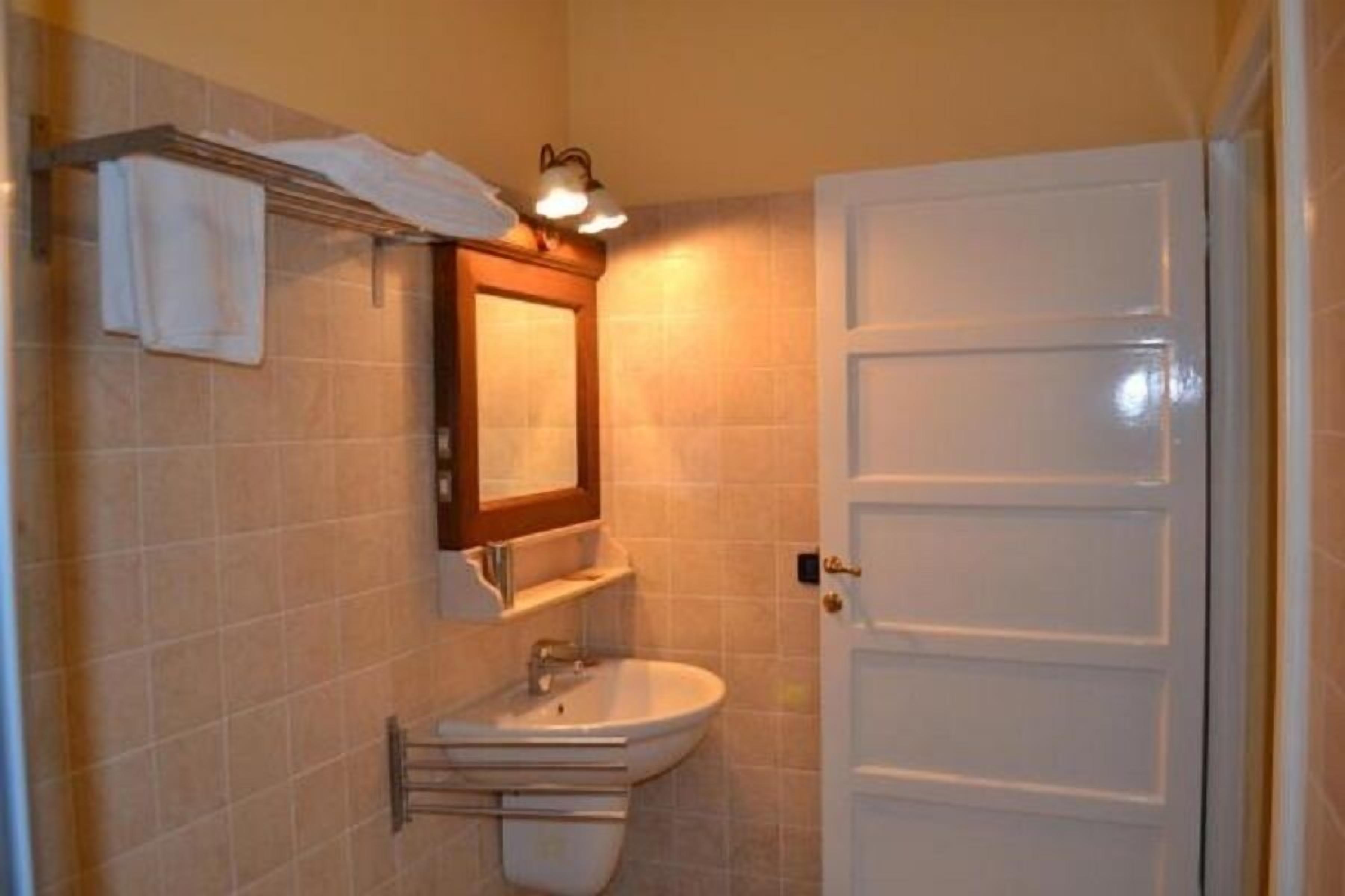 A bathroom with a white sink, a mirror, and a towel rack.