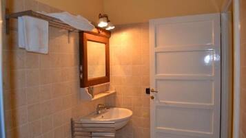 A bathroom with a white sink, a mirror, and a towel rack.