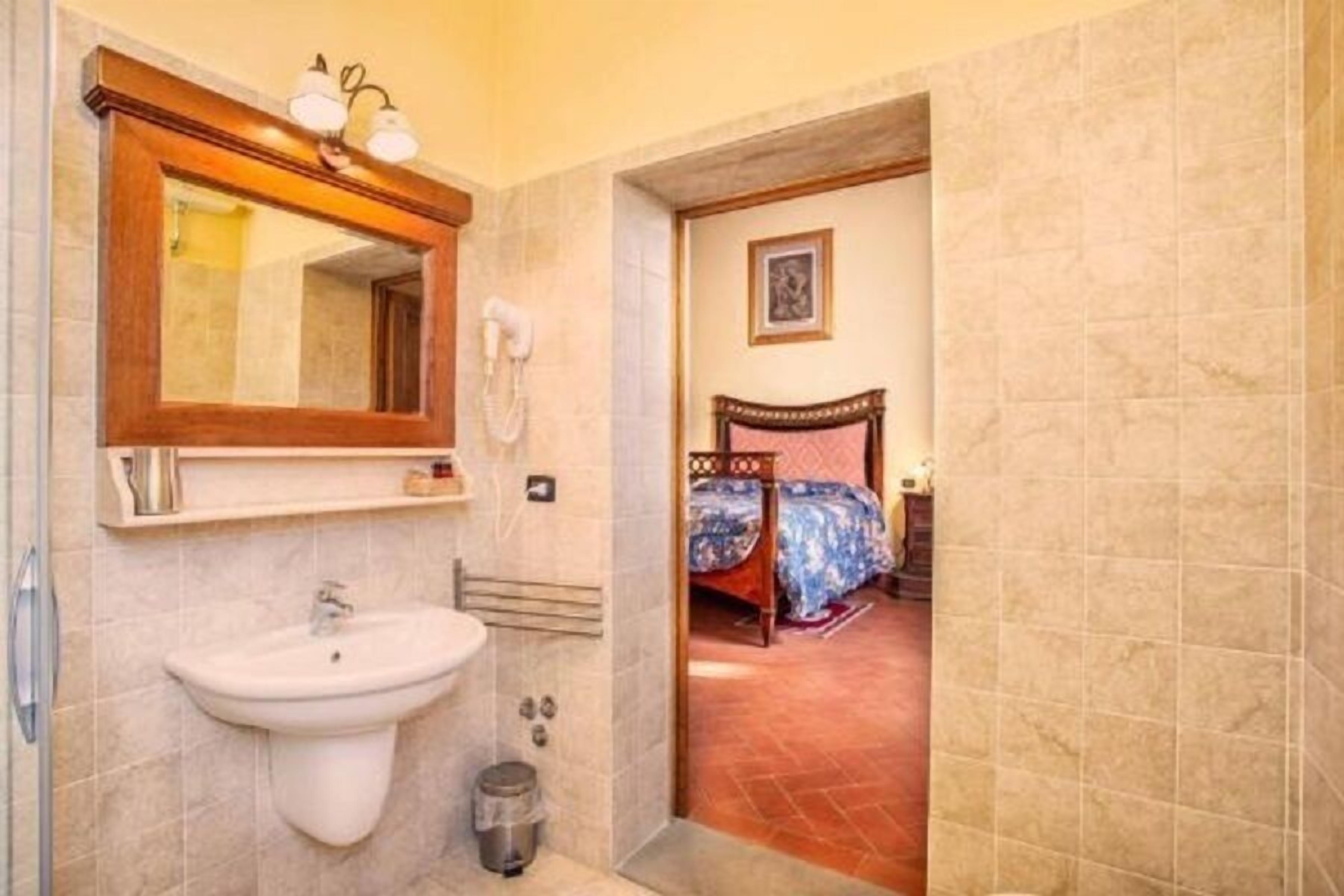 A bathroom with a sink, mirror, and telephone.