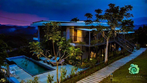 A modern two-story building with a swimming pool, surrounded by lush greenery and a staircase leading to a balcony. - Ragamaya Resort & Spa Munnar (Udumbanchola)
