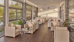A spacious lounge area with multiple seating options, large windows, and a modern design. - Ragamaya Resort & Spa Munnar (Udumbanchola)