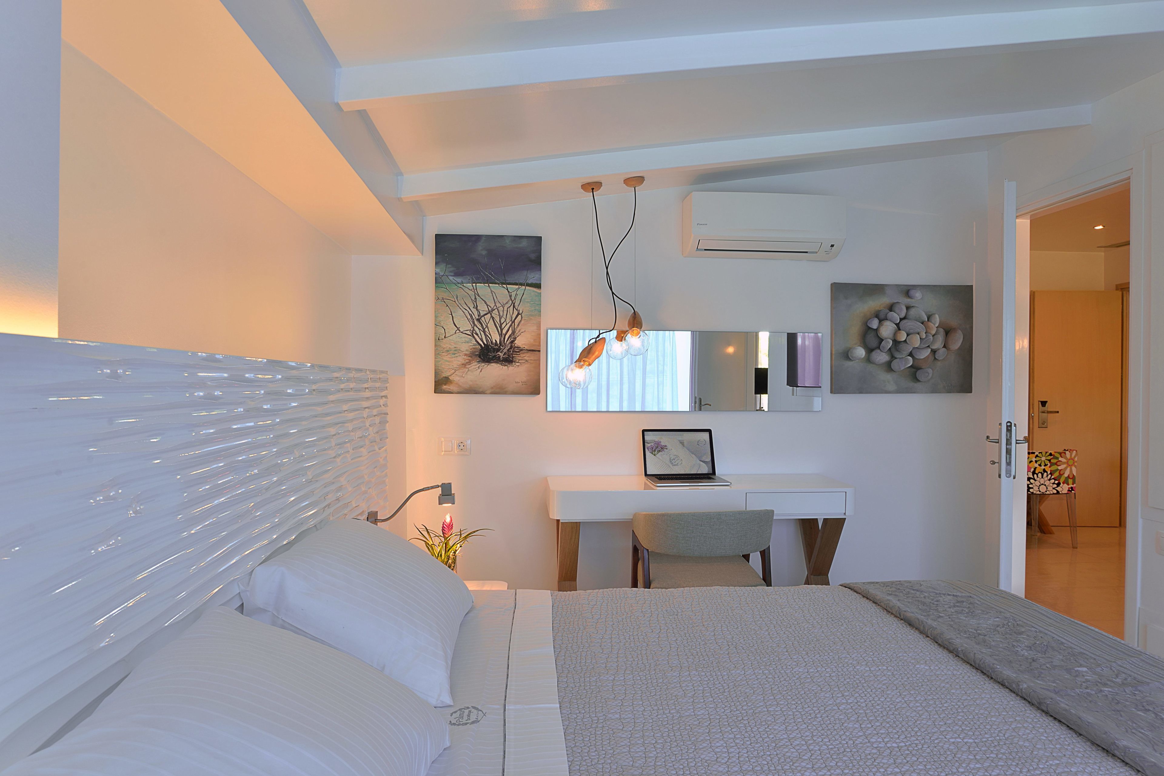 A modern bedroom with a bed, a desk, and a chair.