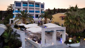 Un hôtel doté d’une terrasse et de palmiers.