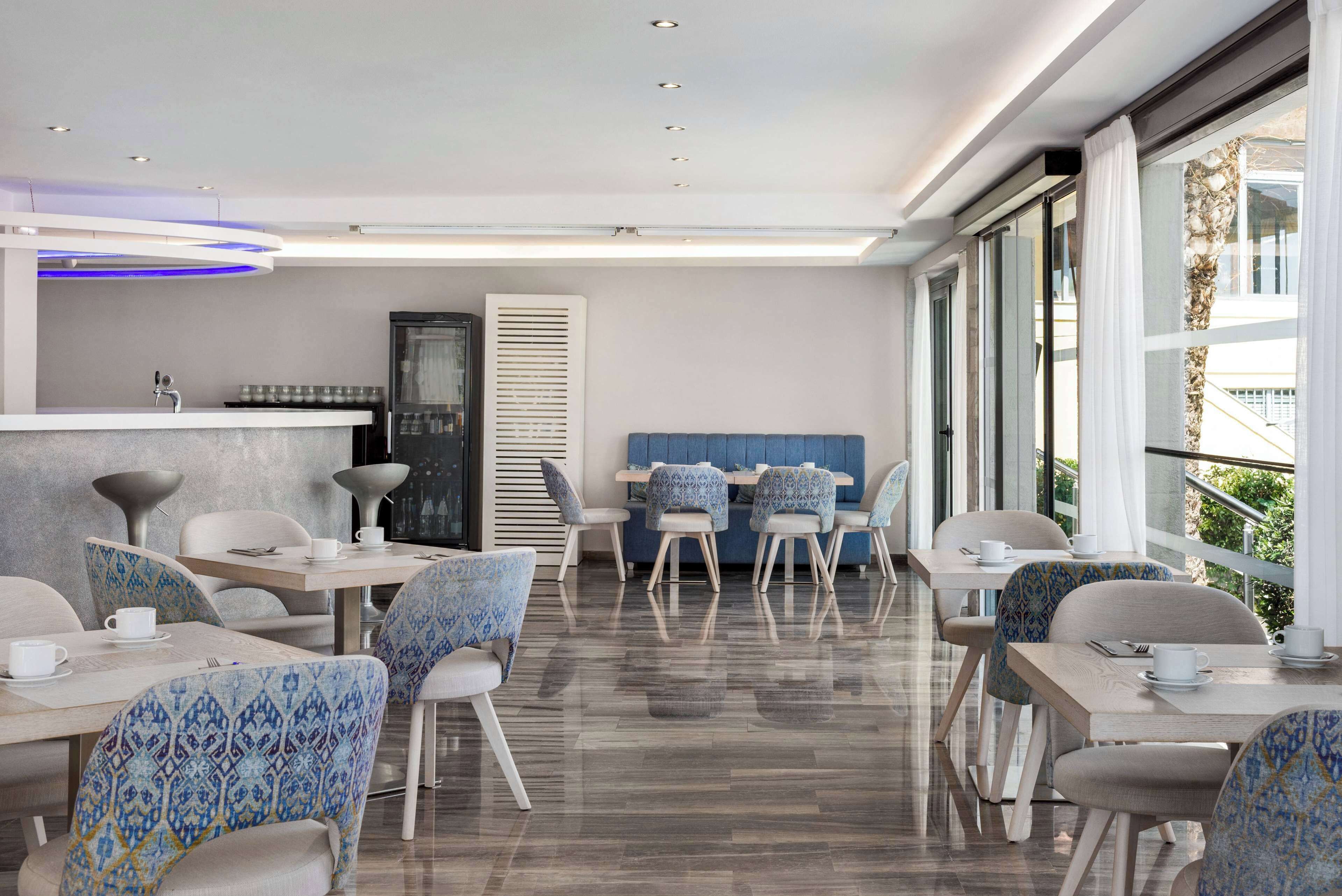 A modern dining area with patterned chairs, a counter, and a view of the outdoors.