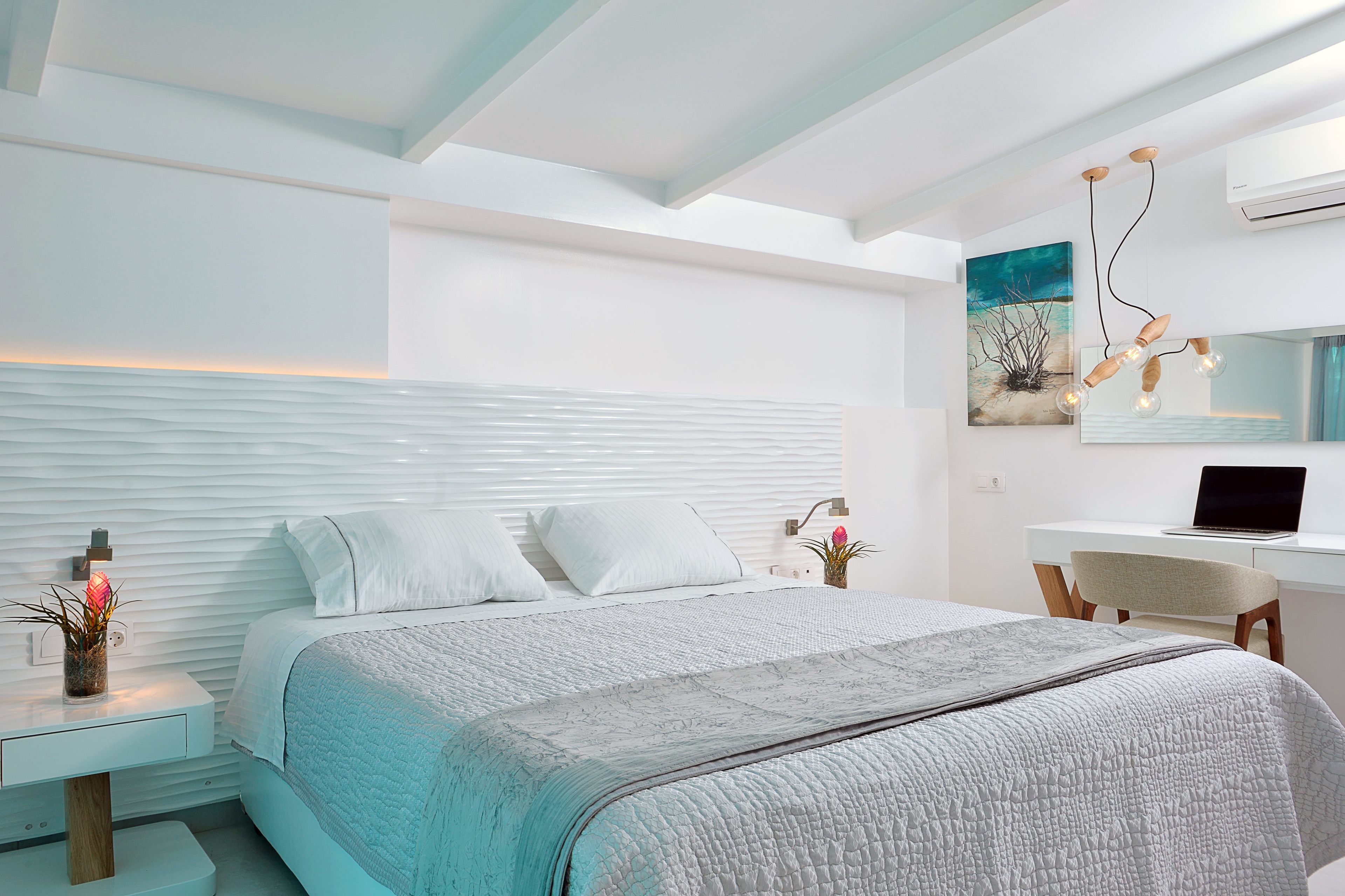 Un dormitorio moderno con una cama grande, un escritorio y una silla.