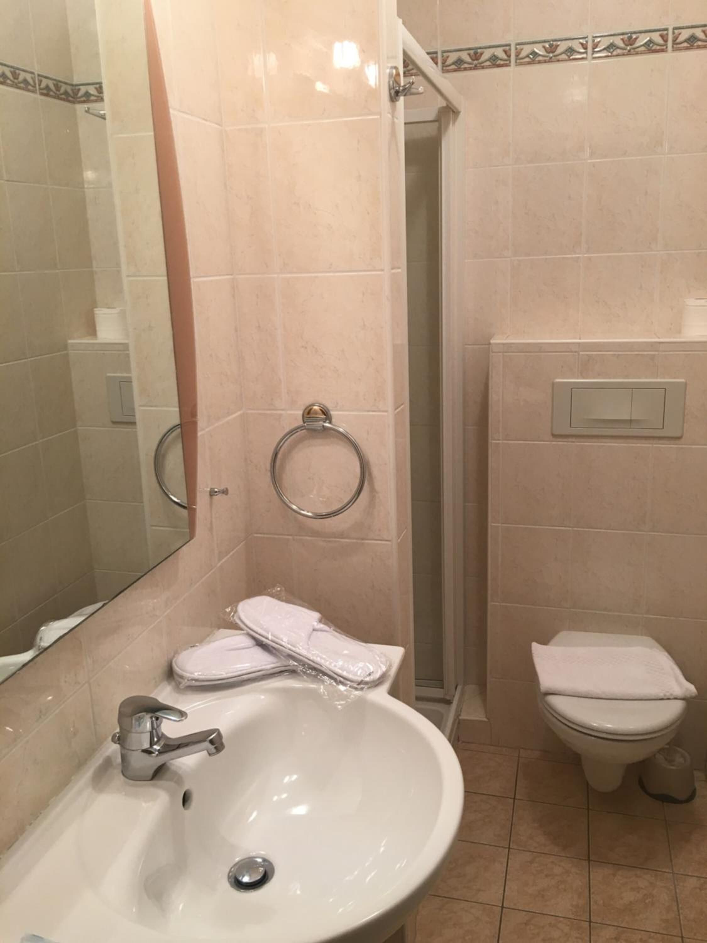 A bathroom with a sink, toilet, and shower.