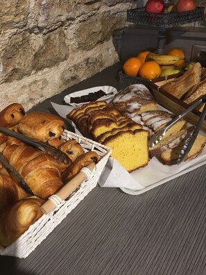 A buffet with pastries, bread, and fruits. - Hôtel & Spa Rodier (Campagnac)