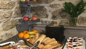 En morgenmadsbuffet med forskellige brød, kager, frugter og tilbehør.