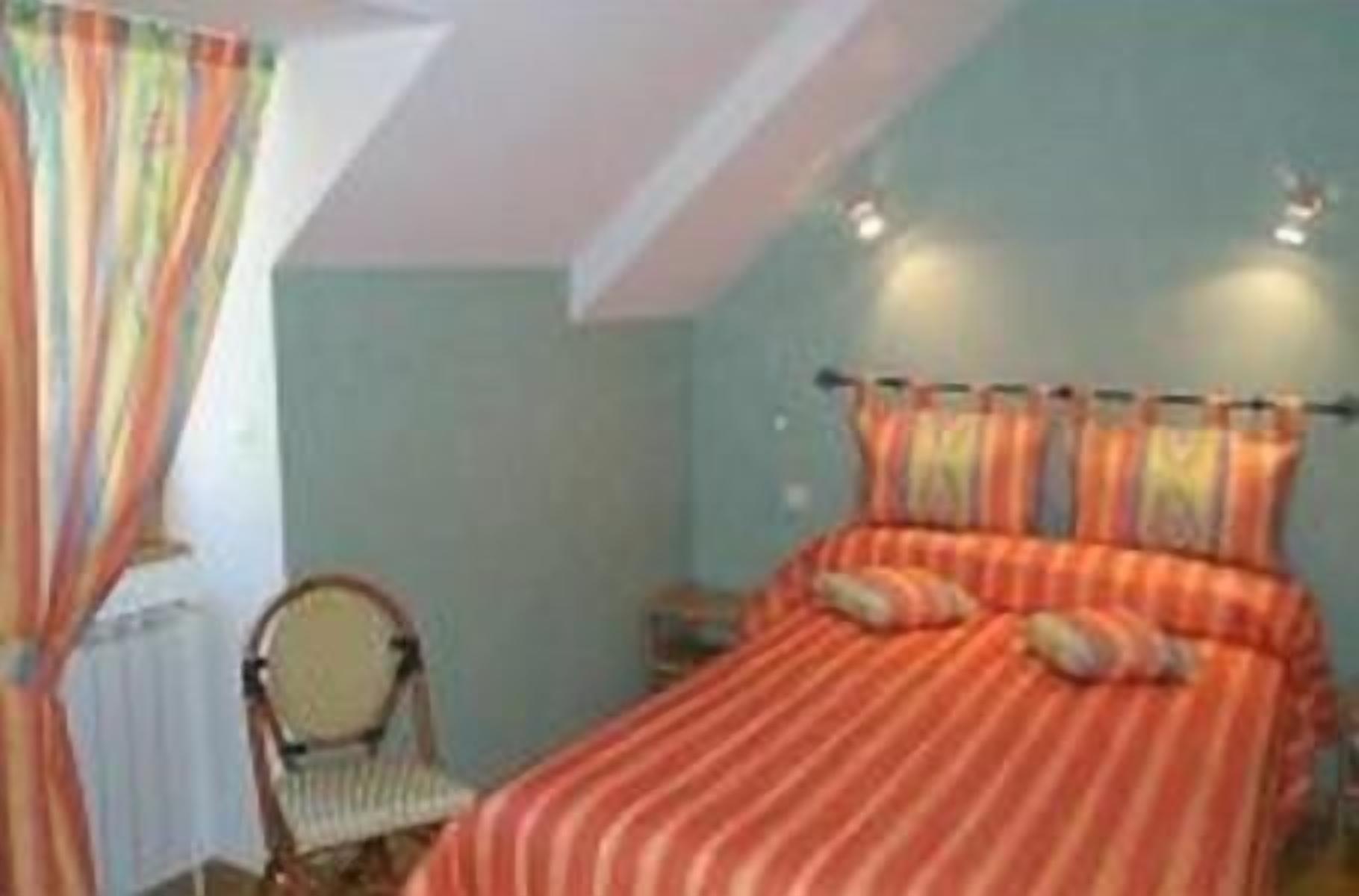 Une chambre à coucher avec un lit, une chaise et une table de chevet.