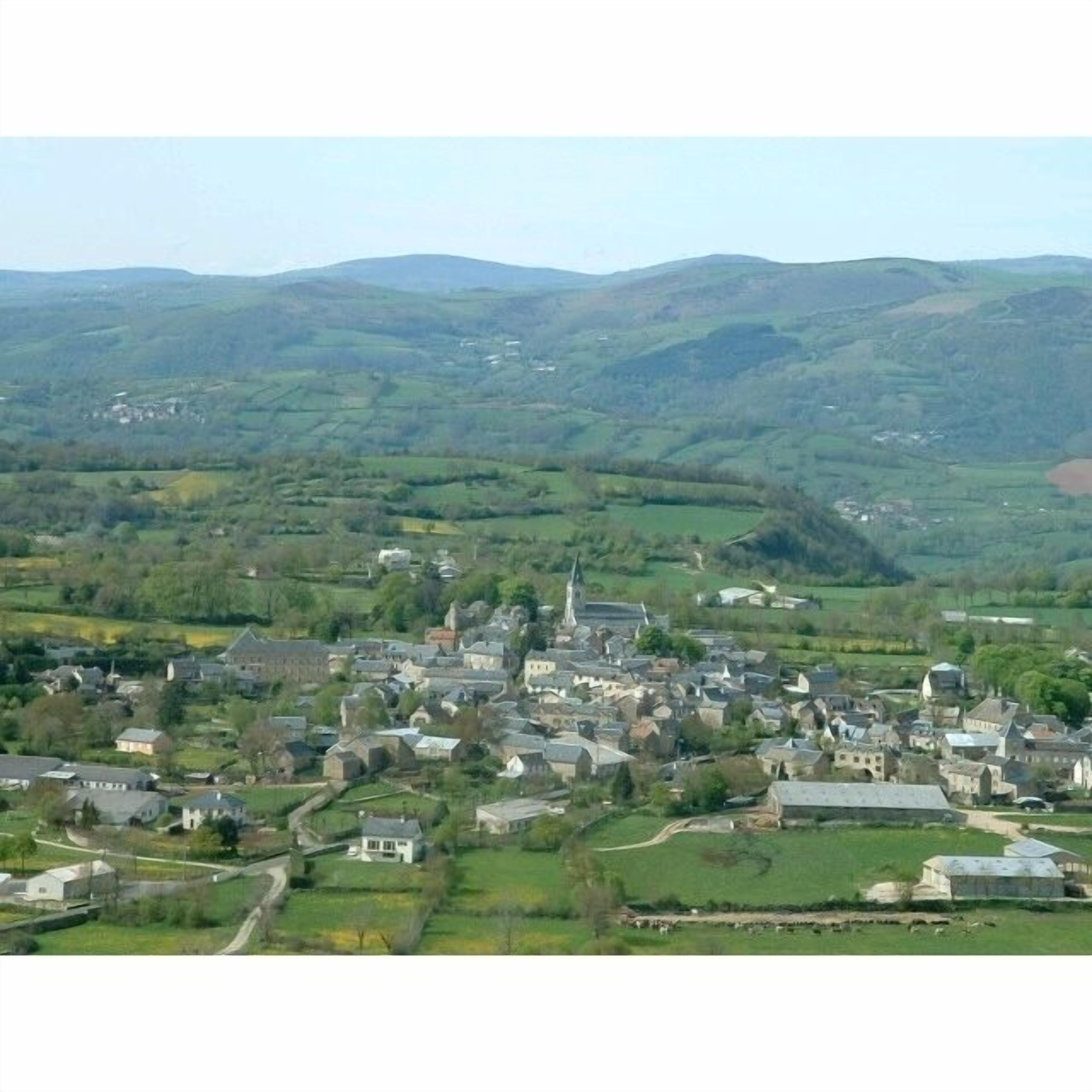 Un pueblo rural con una iglesia destacada y campos circundantes.