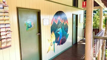 Un bâtiment avec une porte verte, une fresque colorée sur le mur et une terrasse en bois.