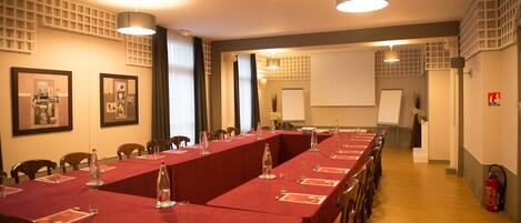 A conference room with a long table, chairs, and a whiteboard.