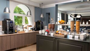 Een moderne keuken met een koffiehoek, een fruitpresentatie en uitzicht op de omgeving.
