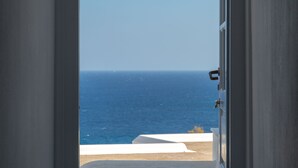 An open doorway leading to a balcony with a view of the sea. - Arkas Inn (Paros)