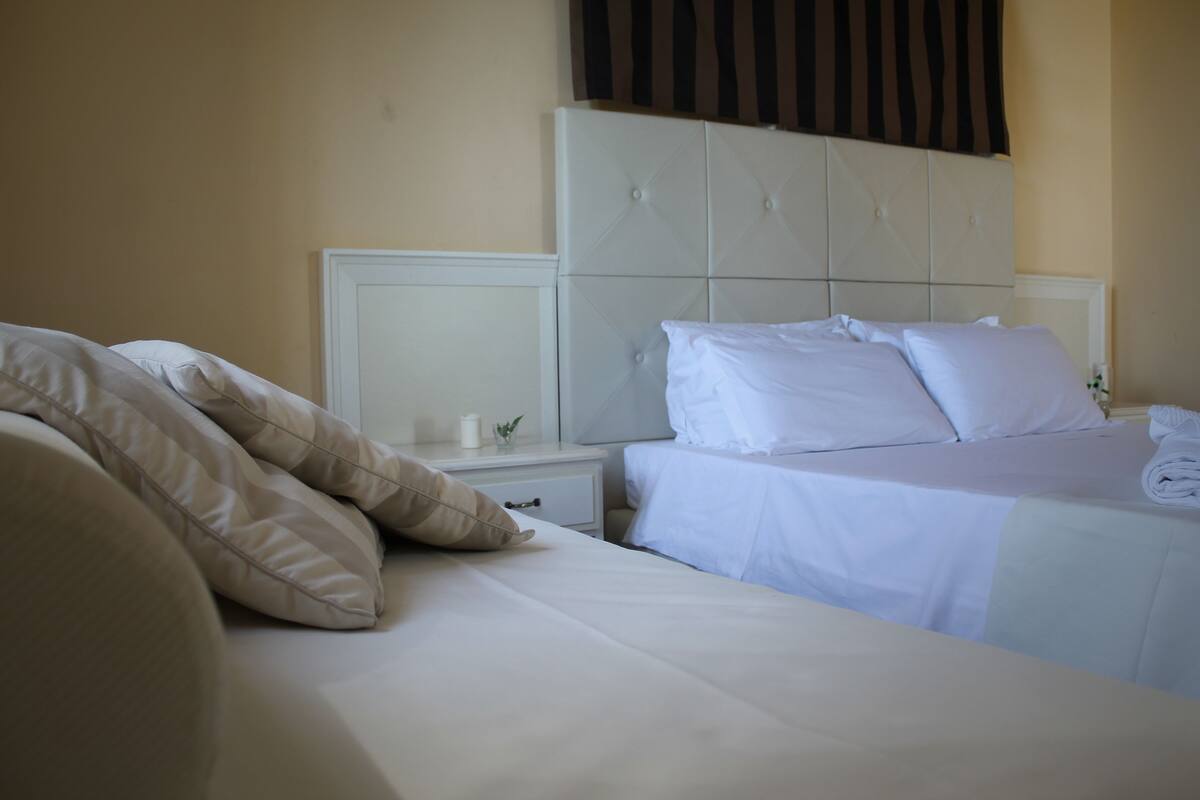 A hotel room with a large bed, a nightstand, and a headboard.