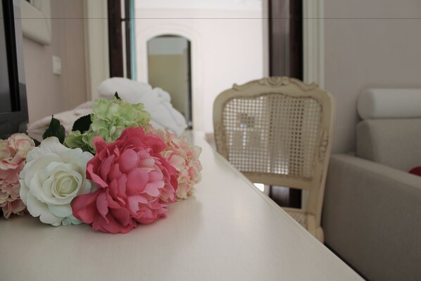 A table with a bouquet of flowers and a wicker chair. - Torre del Mare (Ispica)