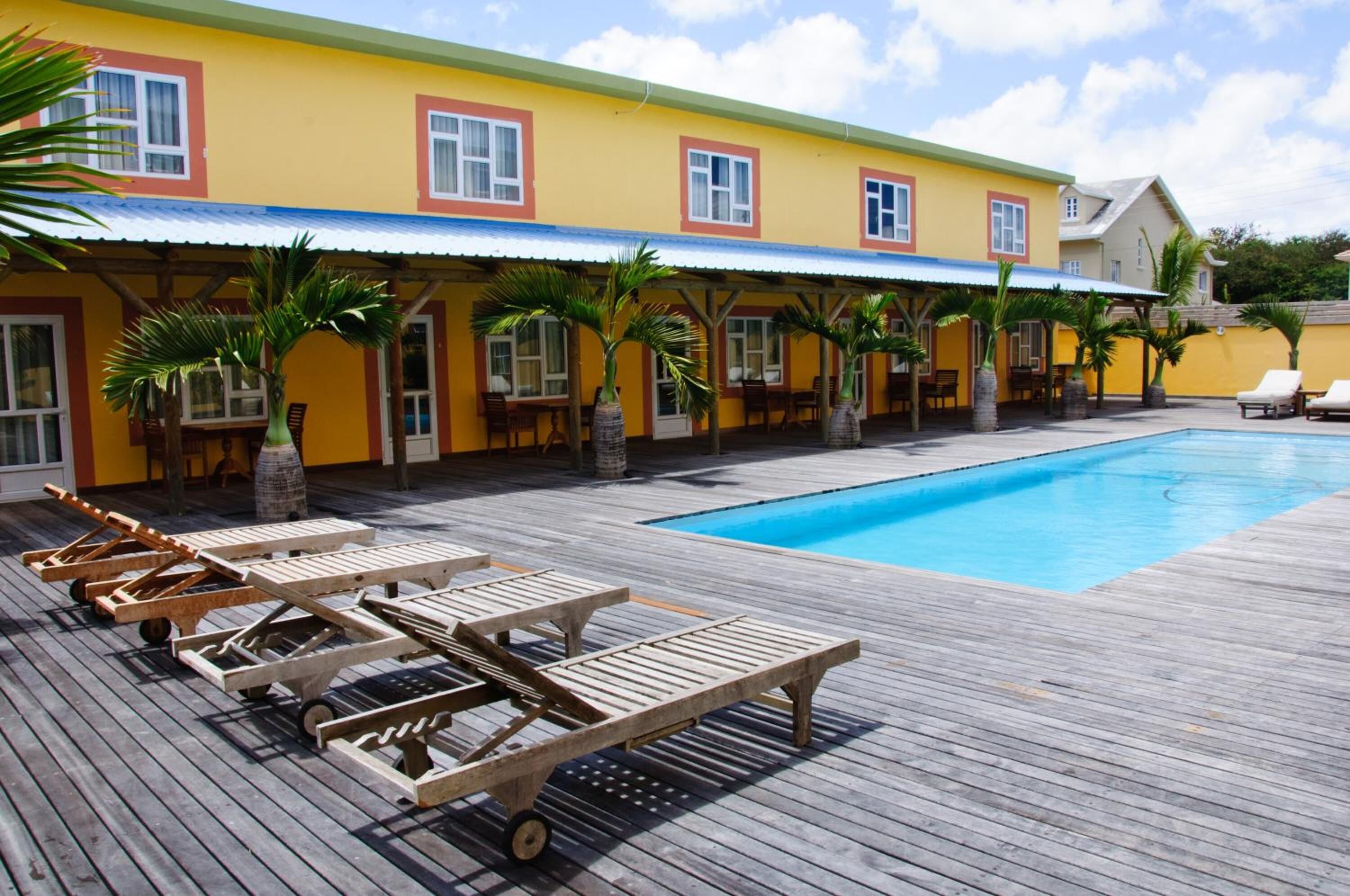 A wooden deck with lounge chairs and a swimming pool.