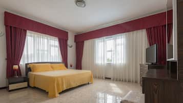A hotel room with a bed, a TV, a nightstand, and a dresser.