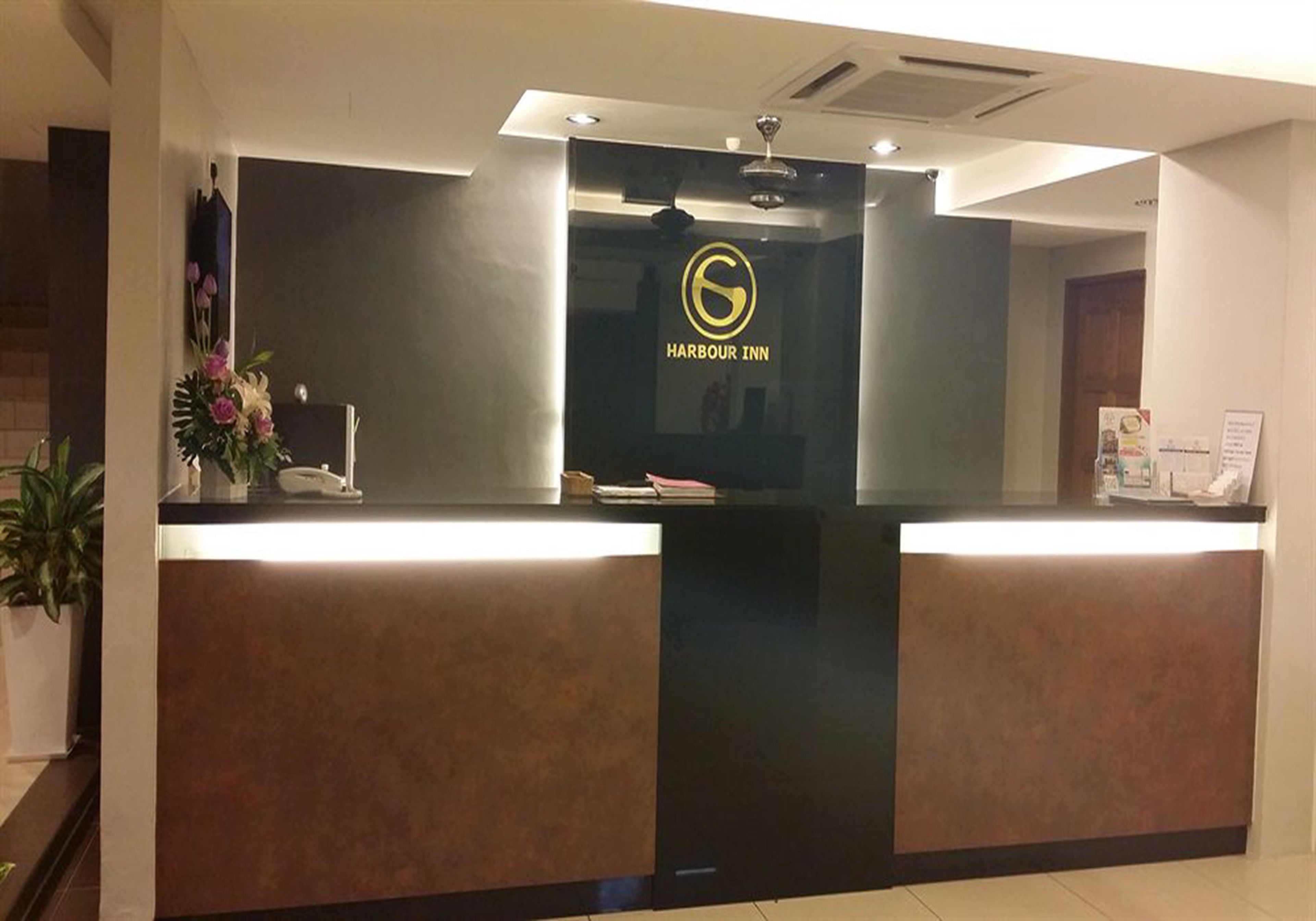 A reception desk with a logo, a plant, and a phone.