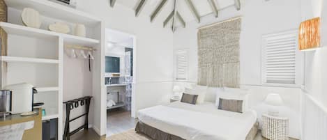 A bedroom with a large bed, bedside tables, a wardrobe, and a view of the bathroom.
