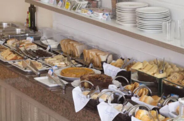 A buffet with various food items and utensils.