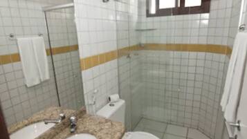 Une salle de bain avec une douche à parois de verre, un lavabo et des toilettes.
