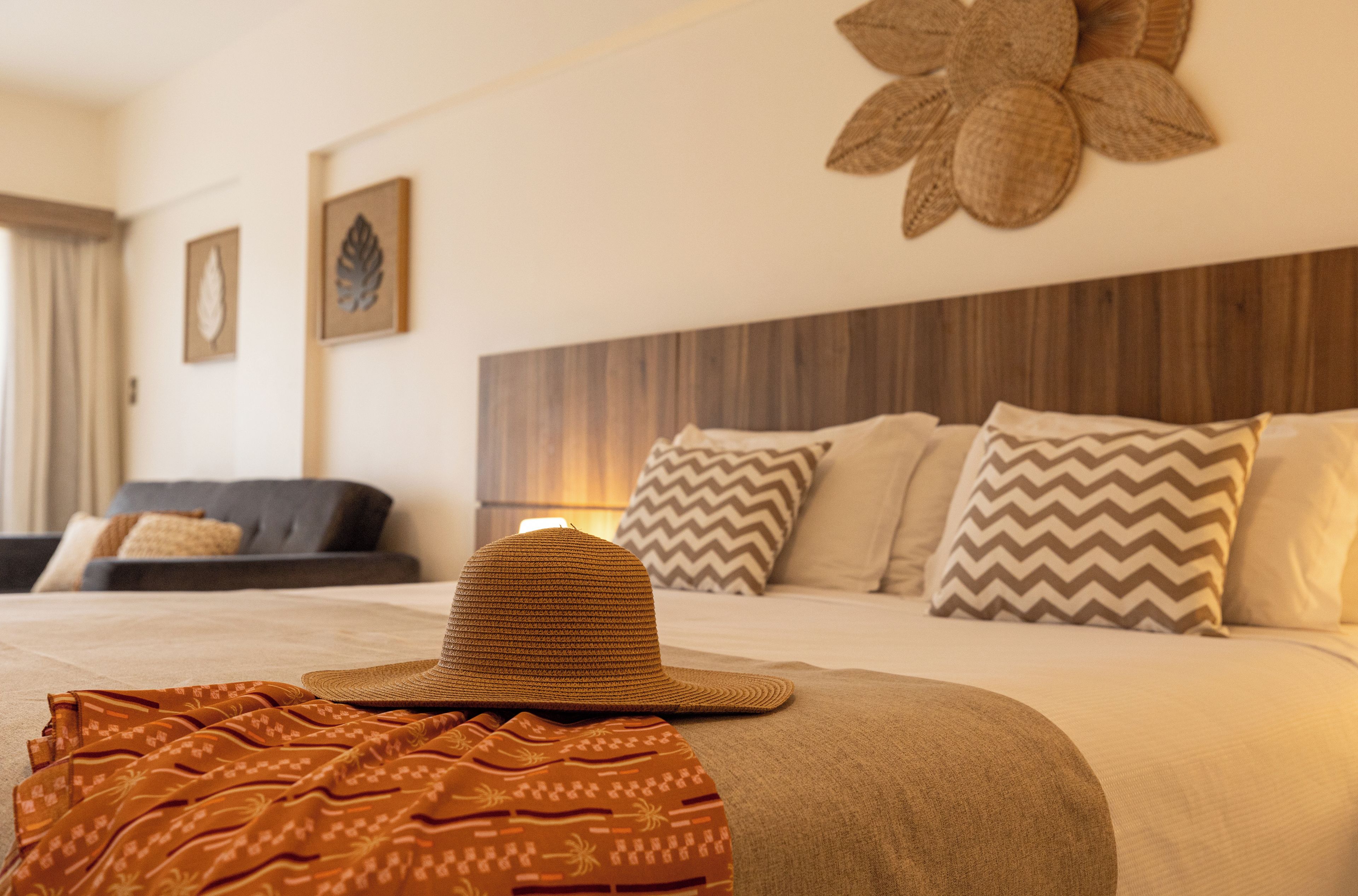 Une chambre d’hôtel avec un lit, un canapé et un élément décoratif fixé au mur.