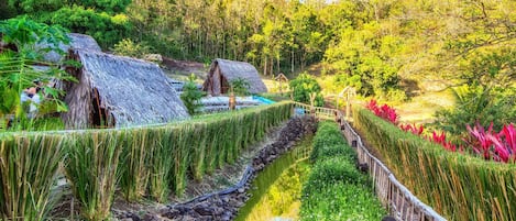 En idyllisk landsby med bindingsværkshuse, en smal vandløb og frodig vegetation.