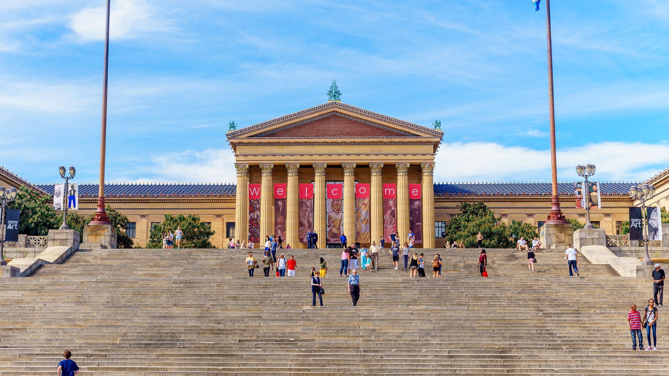 A grand building with a classical architectural style, featuring a prominent entrance with steps leading up to it.