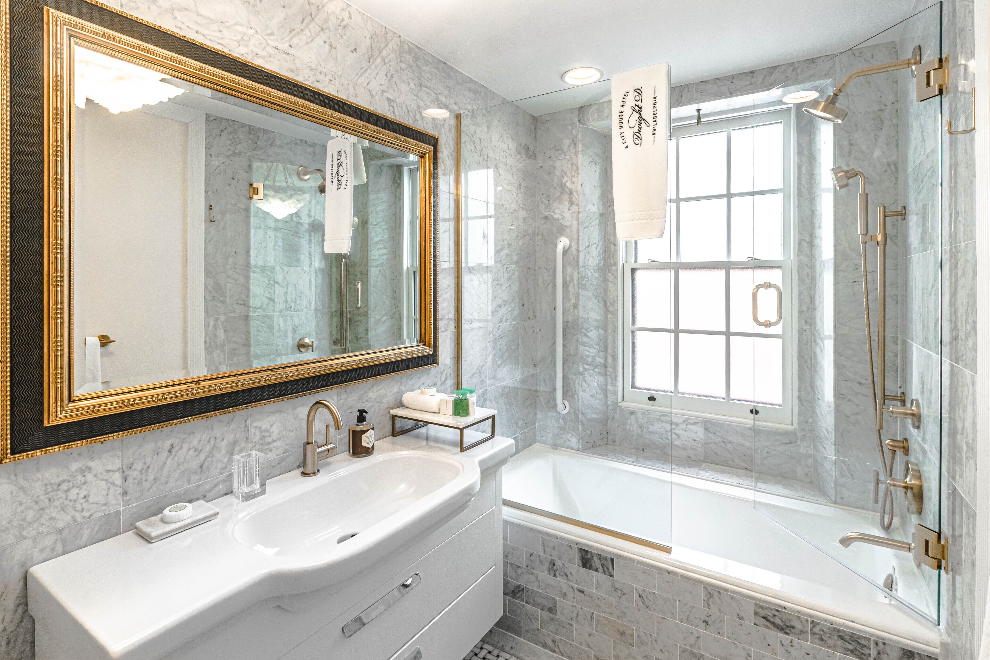 A bathroom with a large mirror, a sink, a bathtub, and a shower.